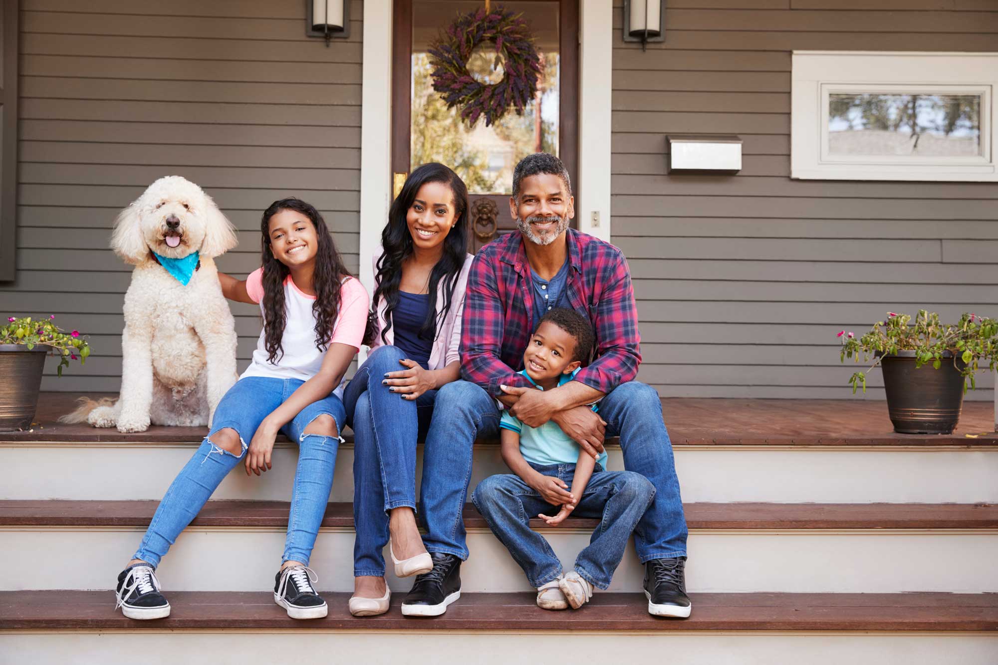 family sitting on porch with dog